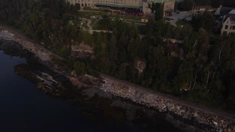 Drohne-Zeigt-Fairmont-Le-Manoir-Richelieu,-Charlevoix,-Quebec,-Kanada,-Berühmte-Luxushotel-Resort-Attraktion,-Luftaufnahmen-Bei-Sonnenuntergang,-Nachts-Beleuchtet