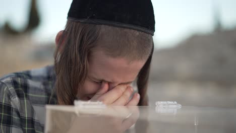 Eine-Nahaufnahme-Eines-Jüdischen-Kindes,-Das-Auf-Einem-Grab-Im-Friedhof-Har-Har-Hamenuchot-In-Israel-Weint
