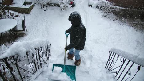 A-man-clears-the-snow-on-the-stairs-to-a-house-with-a-shovel
