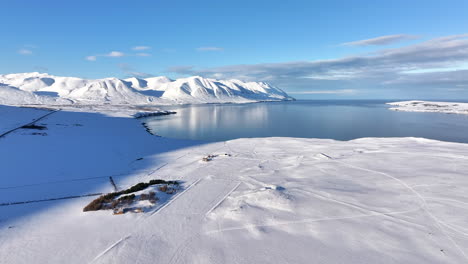 Impresionante-Vista-De-La-Alta-Montaña-Cubierta-De-Nieve-En-Una-Tranquila-Bahía-En-Islandia