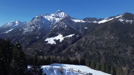 Vista-Aérea-De-Drones-Pasó-Por-Bancos-En-El-Mirador-De-Los-Alpes-Austriacos,-Vista-Sobre-El-Paisaje-Montañoso-Cubierto-De-Nieve-Con-Bosque-De-Pinos