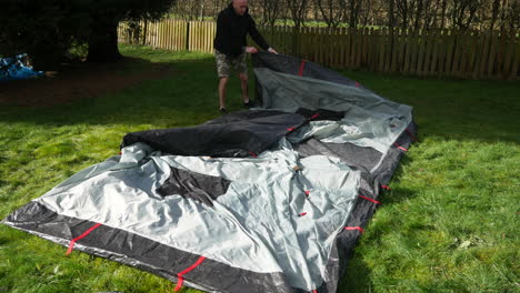 A-man-packing-away-a-tent-folding-it-up