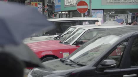 Tráfico-De-Hong-Kong-Durante-Las-Horas-Pico-Con-Peatones,-Automóviles-Y-Taxis-Durante-Un-Día-Nublado---Cámara-Lenta