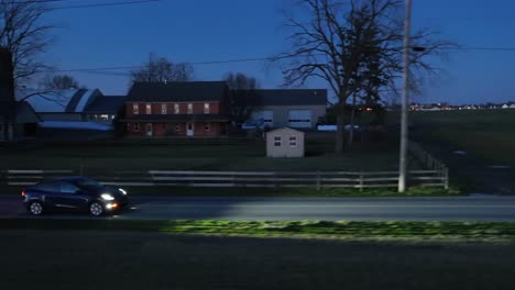 Tesla-Modelo-Azul-Y-Conduciendo-Por-Una-Carretera-Rural-De-EE.UU.-Con-Granja
