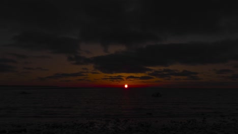 Sunset-over-calm-a-lake-at-Port-Elgin-with-clouds-streaking-across-the-sky,-timelapse