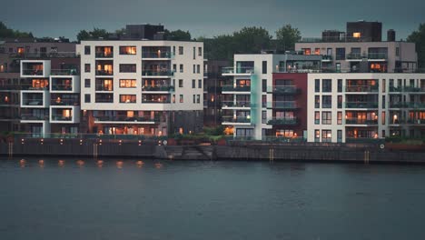Moderne-Wohngebäude-Mit-Hell-Erleuchteten-Fenstern-Im-Küstenviertel-Der-Stadt-Kristiansand