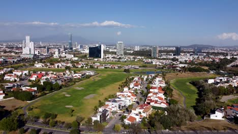 Toma-Aérea-De-Establecimiento-Que-Muestra-El-Campo-De-Golf-Y-El-Vecindario-Suburbano-En-Un-Día-Soleado