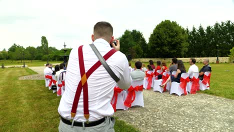 Un-Fotógrafo-Toma-Fotografías-De-Boda-Durante-La-Ceremonia-Secular,-Código-De-Vestimenta-Rojo-Y-Blanco