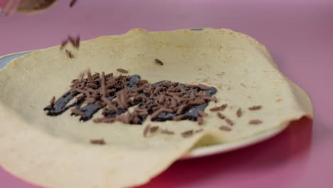 Schokoladenstückchen-Auf-Einem-Crêpe-Verteilen
