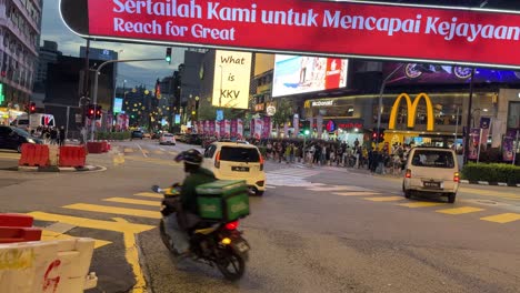 Kuala-Lumpur-Bukit-Bintang-main-intersection-cars-passing-at-night-Malaysia