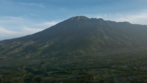 Magnificent-nature-drone-flying-over-rural-landscape-with-view-of-Merbabu-Mountain,-Indonesia