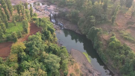 AERIAL-DRONE-VIEW-drone-Camera-is-moving-forward-where-a-large-waterfall-is-falling-and-a-large-river-and-lots-of-bushes-are-also-visible