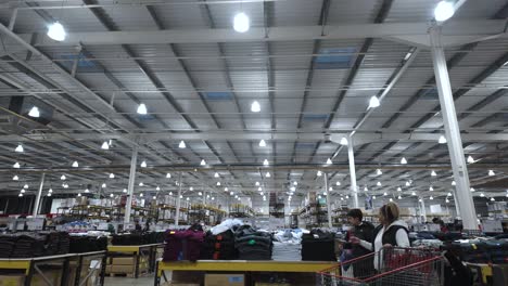 Inside-View-Of-Expansive-Costco-Warehouse-With-View-Of-Clothes-Stacked-On-Tables