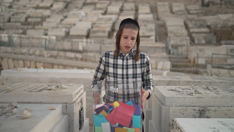 jewish-kid-walking-betwen-graves-in-Har-HaMenuchot-Cemetery-and-stoping-by-a-grave