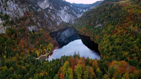 Der-Ruhige-Topletz-See-Liegt-Im-Herbst-Inmitten-Farbenfroher-Bäume-Und-Majestätischer-Berge,-Ein-Gewässer-Am-Ufer-Einer-Bergkette