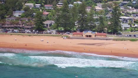 Aerial-reveal-from-the-sand-and-life-saving-area-of-Palm-Beach-to-the-surfers-waiting-on-the-water