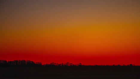 Red-and-orange-sky-with-tree-line-silhouette