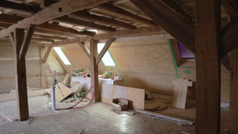 Interior-attic-construction-site-with-hempcrete-wall-and-visible-timber-frames,-panning-left-to-right