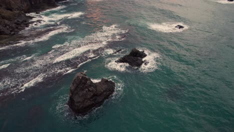 Drone-Aéreo-Cerca-De-La-Playa-Acantilado-Rocas-Islotes,-Mar-Azul-Puesta-De-Sol-Playa-De-Kyotango-Japón,-Kyoto-Kansai,-Destino-De-Viaje,-Entorno-Natural-Estableciendo-Toma
