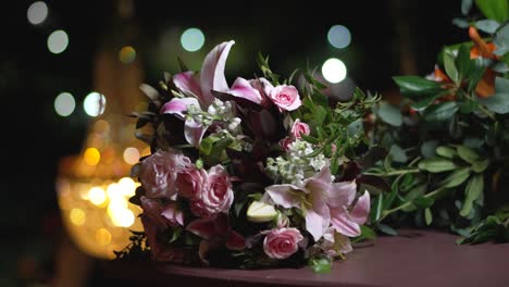 Wedding-bouquet-with-flowers-of-lilies-and-roses-lies-on-a-table