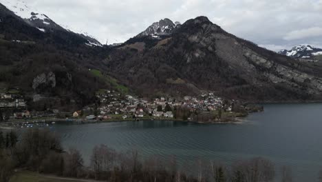Pan-establishes-idyllic-peaceful-community-on-shoreline-of-lake-in-Walensee-Switzerland-at-base-of-mountains