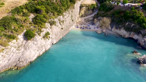 Retreating-drone-of-the-picturesque-rocky-cliffs-and-marine-caves-in-the-sulphurous-waters-of-Xigia-Beach,-situated-in-Zakynthos-island-in-Greece