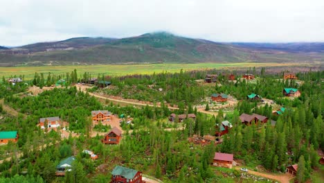 Luftaufnahme-Einer-Kleinen-Bergstadt-Mit-Häusern,-Umgeben-Von-üppigen-Sommerwäldern-In-Den-Rocky-Mountains-Auf-Großer-Höhe