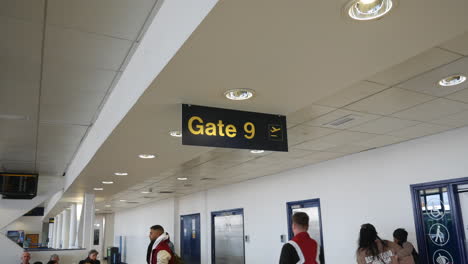Terminal-9-Del-Aeropuerto,-Puerta-Nueve,-Cartel-En-Una-Concurrida-Zona-De-Espera-De-La-Sala-De-Embarque