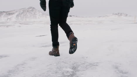 Person-walking-on-icy-ground-in-snowy-Icelandic-landscape