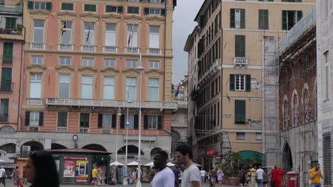 Toma-Panorámica-Que-Muestra-Una-Concurrida-Plaza-Con-Mucha-Gente-Caminando-En-Todas-Direcciones-En-La-Tradicional-Ciudad-Italiana