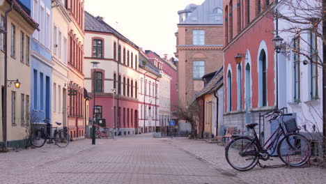 Calle-Adoquinada-Vacía-En-Gamla-Staden-Con-Bicicletas-Estacionadas-Y-Edificios-Coloridos