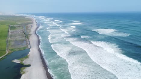 Playa-Y-Naturaleza-Juntas-En-Un-Hermoso-Cielo-Azul-Con-Las-Olas-Besando-Las-Arenas-Grises