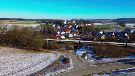 Snow-Dusted-Village-with-Passing-Train-in-Rural-Landscape