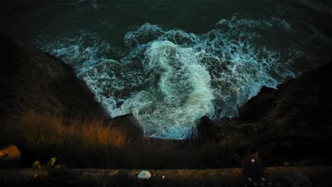 Slow-motion-of-rising-tides-at-the-base-of-a-cliff-at-sunset