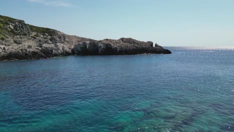 Aerial-view-of-the-rocky-coastline-and-clear-blue-water