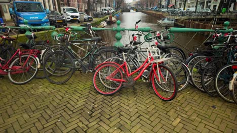 Endless-row-of-Amsterdam-bikes-lined-up-next-to-Dutch-canal-travel-to-right