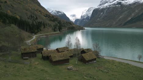 Tranquilo-Paisaje-Escandinavo-Con-Casas-Tradicionales-Con-Techo-De-Pasto-Junto-Al-Lago-Lovatnet,-Noruega,-Colores-Otoñales