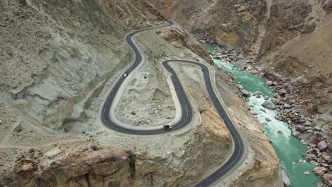 Vista-Aérea-De-Vehículos-Paquistaníes-Circulando-Por-Carreteras-Con-Curvas-En-Skardu,-Pakistán.