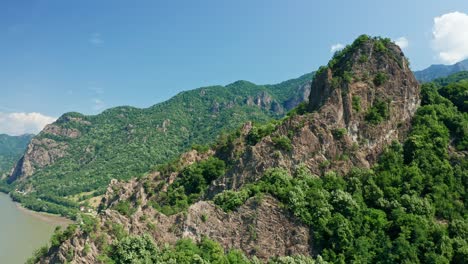 Verdant-Cozia-Mountains-under-blue-skies-with-the-prominent-Pietrele-Rosiei-Peak