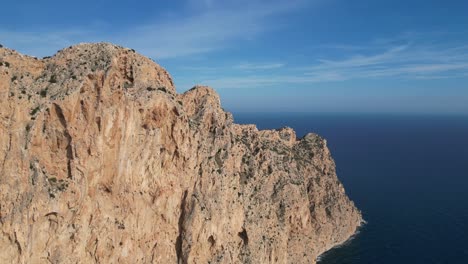 Calpe-Steep-Rock-Cliff-Penon-de-Ifach-Nature-Park-at-Costa-Blanca,-Spain---Aerial-4k