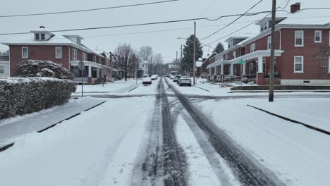 Aerial-forward-flight-over-wet-snowy-street-in-american-suburb