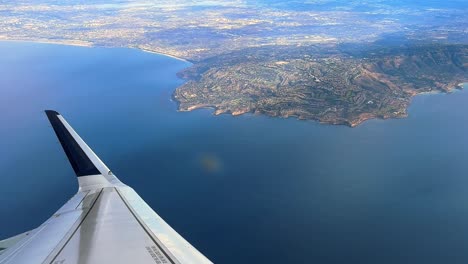 Looking-out-a-commercial-airplane-window-at-the-Los-Angeles-coastline