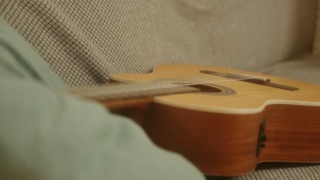 Guitarra-Acústica-Marrón-En-Un-Sofá