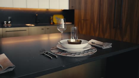 plate-set-up-on-a-black-kitchen-island-in-a-modern-dark-toned-kitchen