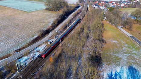Red-Commuter-Train-Navigating-Through-Frosty-Rural-Landscape