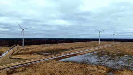 Aerial-field-with-three-wind-turbines-in-the-background