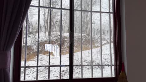 Looking-outside-snowfall-in-forest-nature-wonderful-cold-winter-freezing-ambient-peaceful-comfort-view-from-inside-home-to-heavy-snow-in-rural-village-countryside-in-Hyranian-nature