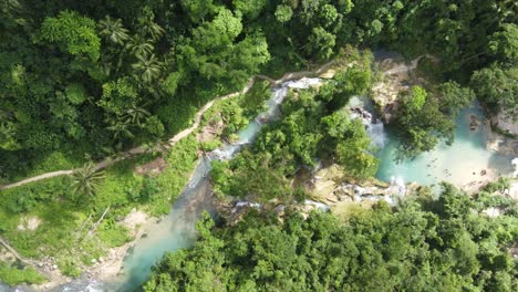 Matutinao-River-Flowing-Through-Lush-Forest-Feeding-Kawasan-Falls,-Aerial-Top-Down