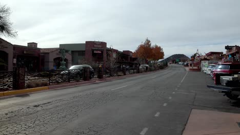 Downtown-Sedona,-Arizona-with-vehicles-and-pedestrians-and-video-panning-right-to-left