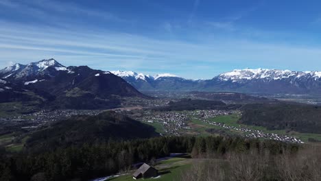 Drohnenaufnahme-Von-Hütten-In-Den-Bergen-Mit-Herrlichem-Blick-über-Die-Winterliche-Berglandschaft-Mit-Schneebedeckten-Bergen-An-Einem-Sonnigen-Tag